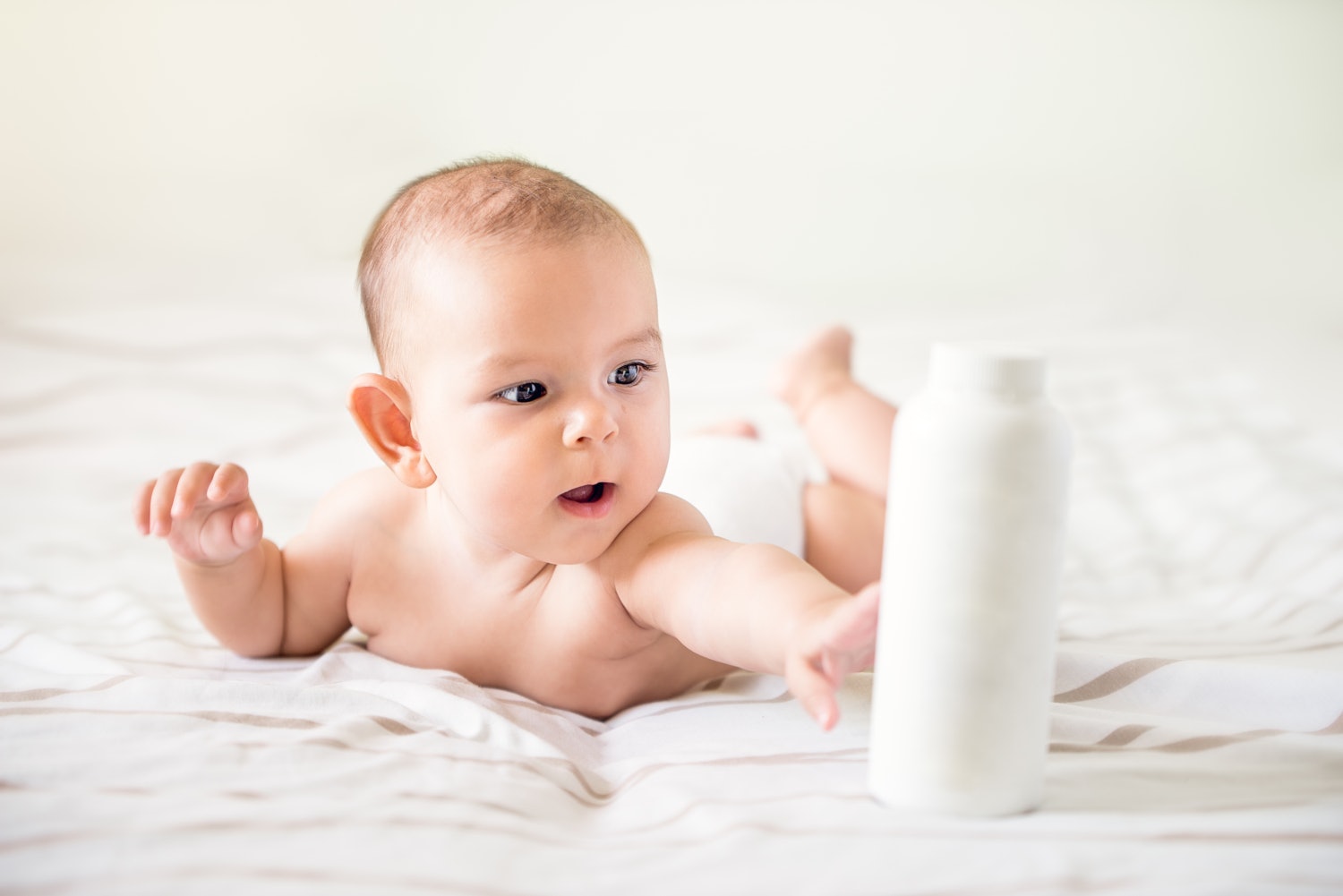 Example Formulation Baby Wash Baby holding a bottle of hand care lotion